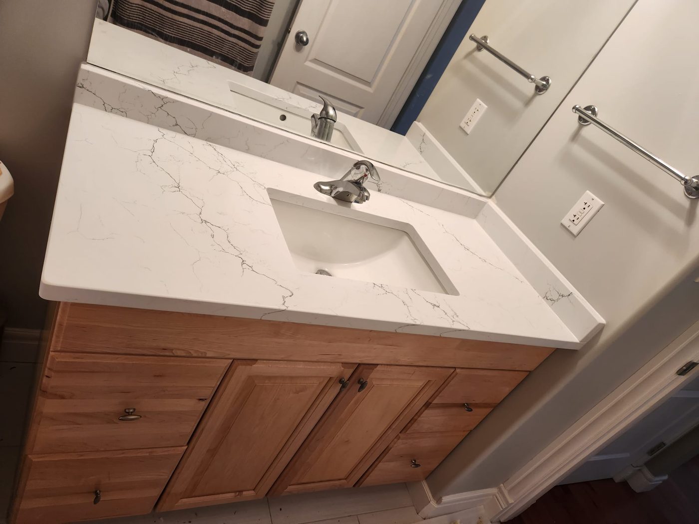 The same vanity after: new white quartz countertop with an integrated basin