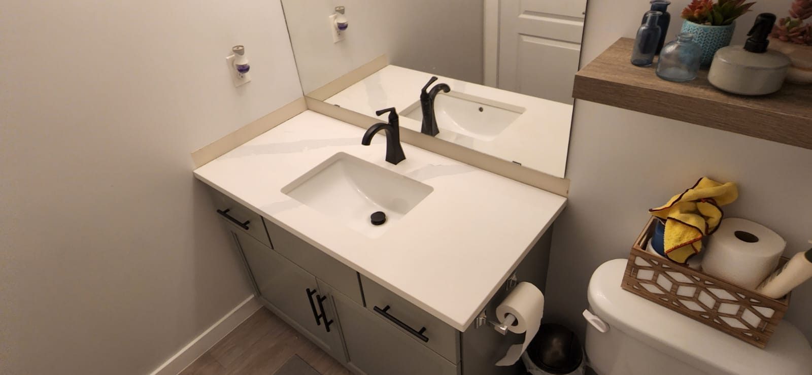 Vanity with a matte black faucet and a light stone top