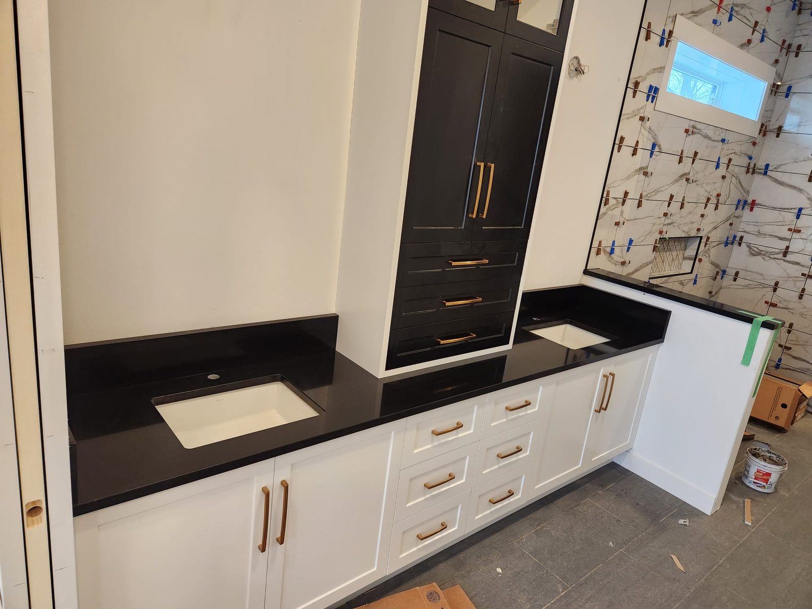 Dark stone counter with custom cabinetry and integrated storage