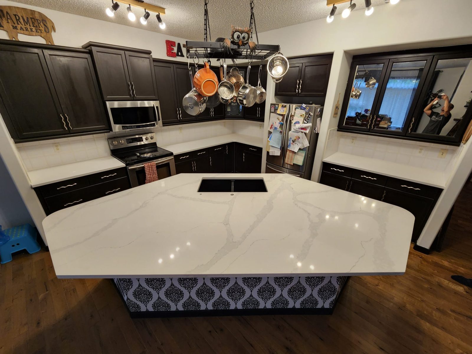 Dark-cabinet Edmonton kitchen with a bright white quartz waterfall island