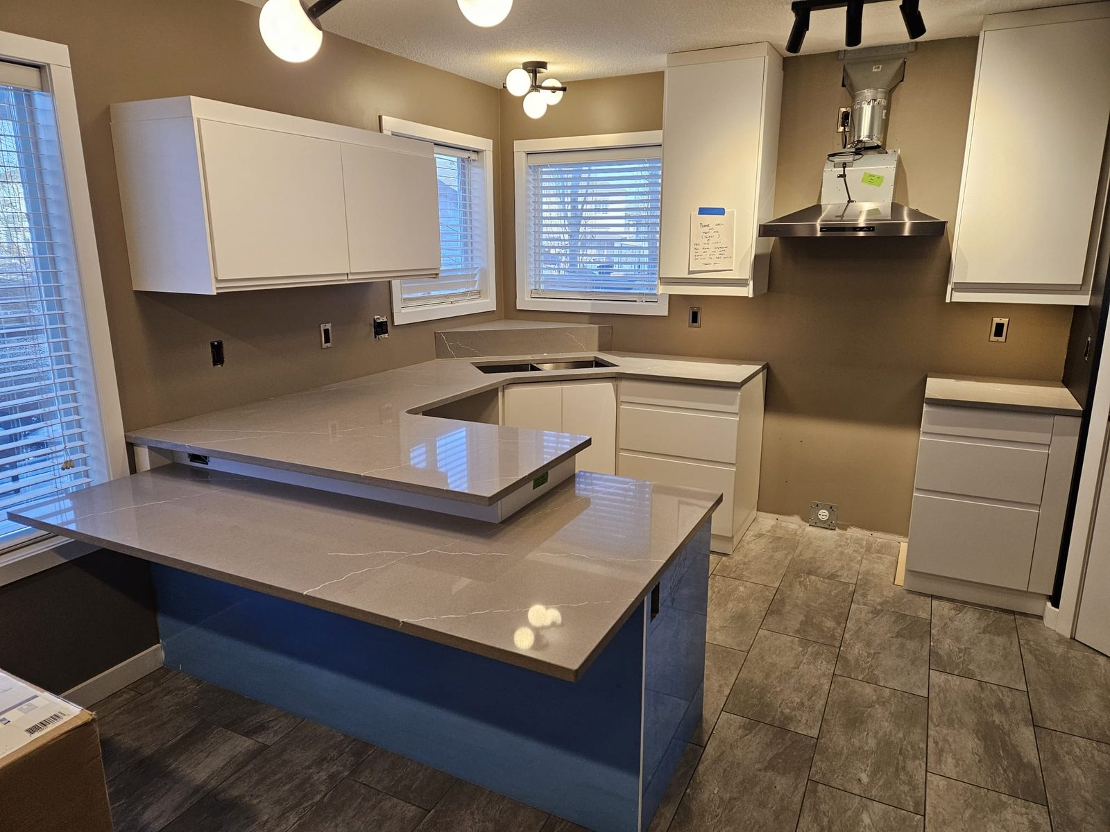 Grey stone kitchen island with a raised bar section