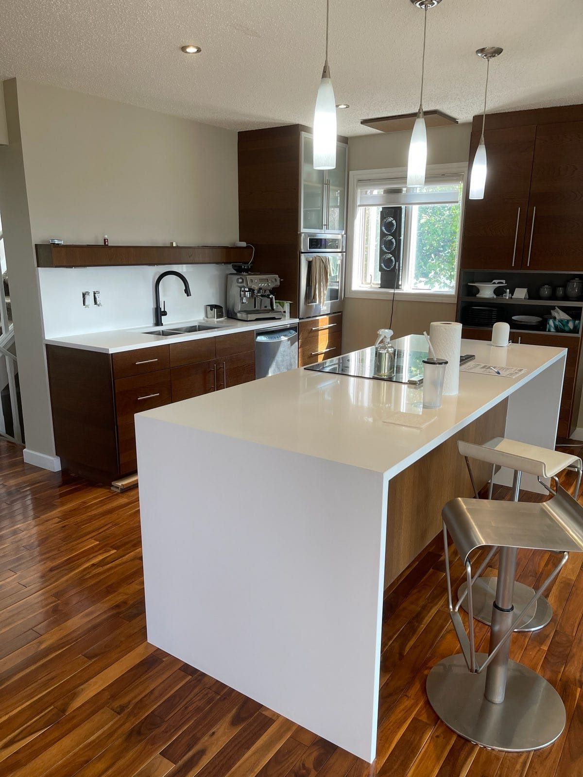 White quartz island in an open-plan kitchen with pendant lighting